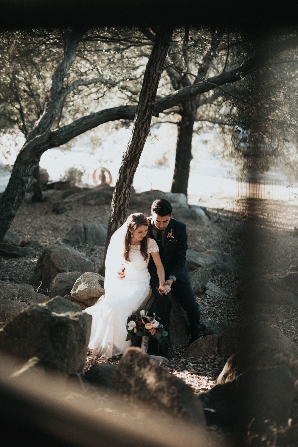 Same day edit video - groom and bride sitting on rock holding hands